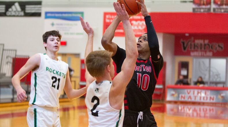 Trotwood-Madison senior Anthony McComb shoots over Cincinnati McNicholas' Clay Badylak during the first half of Saturday's Division II district final at Princeton High School. Jeff Gilbert/CONTRIBUTED