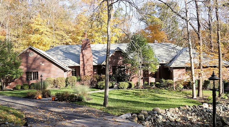 The brick ranch sits back off a paved driveway with a concrete bridge and ends with stonewall accented parking pad. A secluded patio is tucked off the driveway among the trees and three other designated outdoor patio spaces are throughout the 1.32-acre wooded property. The house has a side-entry, 3-car garage. CONTRIBUTED PHOTO BY KATHY TYLER
