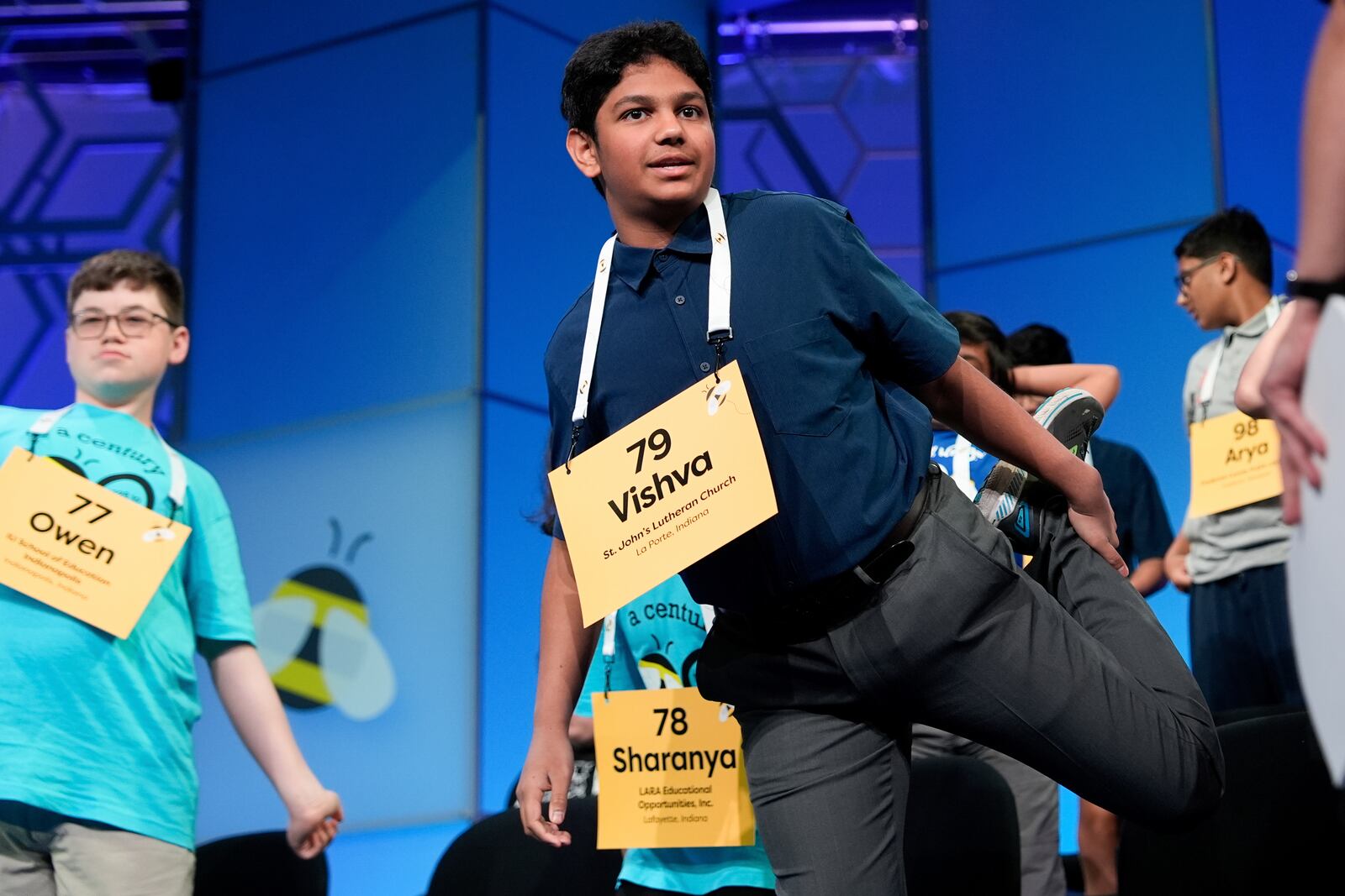 Vishva Bharath, 13, of La Porte, Ind., stretches during a commercial break in the first preliminary round of the Scripps National Spelling Bee, Tuesday, May 27, 2025, in Oxon Hill, Md. (AP Photo/Julia Demaree Nikhinson)