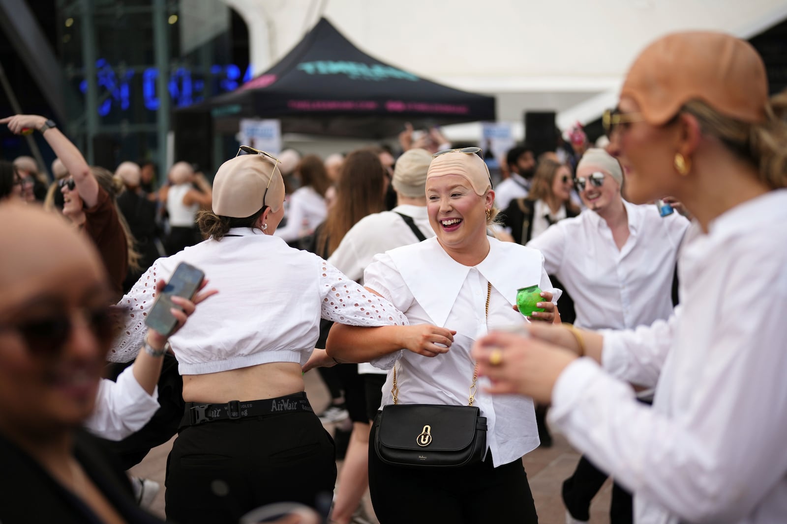 Fans dance in front of the O2 Arena prior to a performance by Pitbull on Monday, June 9, 2025, in London. (Photo by Scott A Garfitt/Invision/AP)