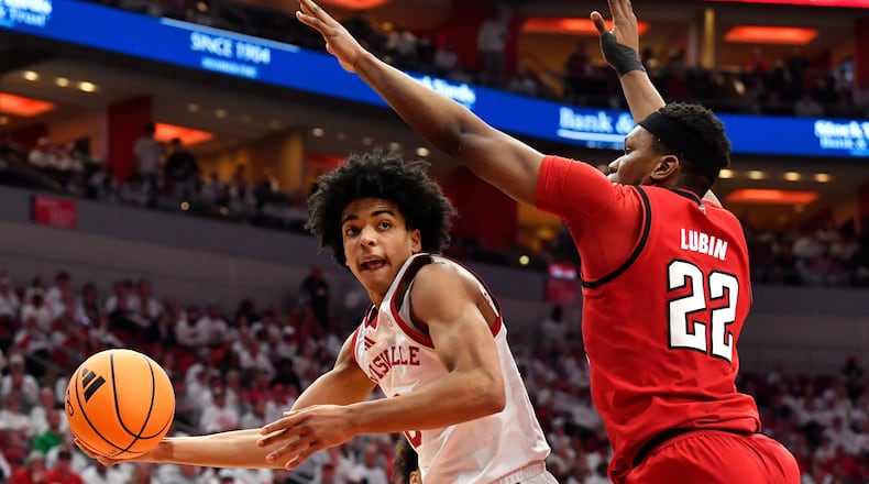 Louisville guard Mikel Brown Jr., left, passes the ball away from North Carolina State forward Ven-Allen Lubin (22) during the second half of an NCAA college basketball game in Louisville, Ky., Monday, Feb. 9, 2026. (AP Photo/Timothy D. Easley)