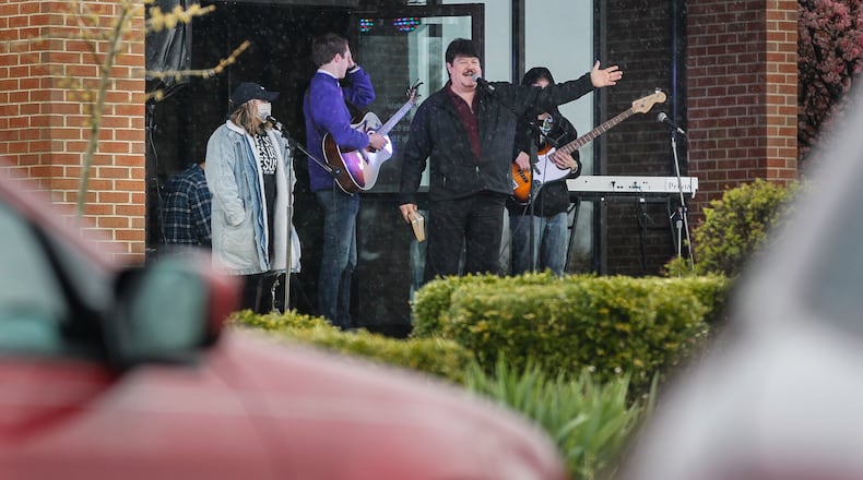 Bruce Jackson, pastor of First Grace Church in Butler Twp., told those gathered in vehicles Sunday to flash their lights to clap and honk horns to “praise the Lord.” CHRIS STEWART / STAFF