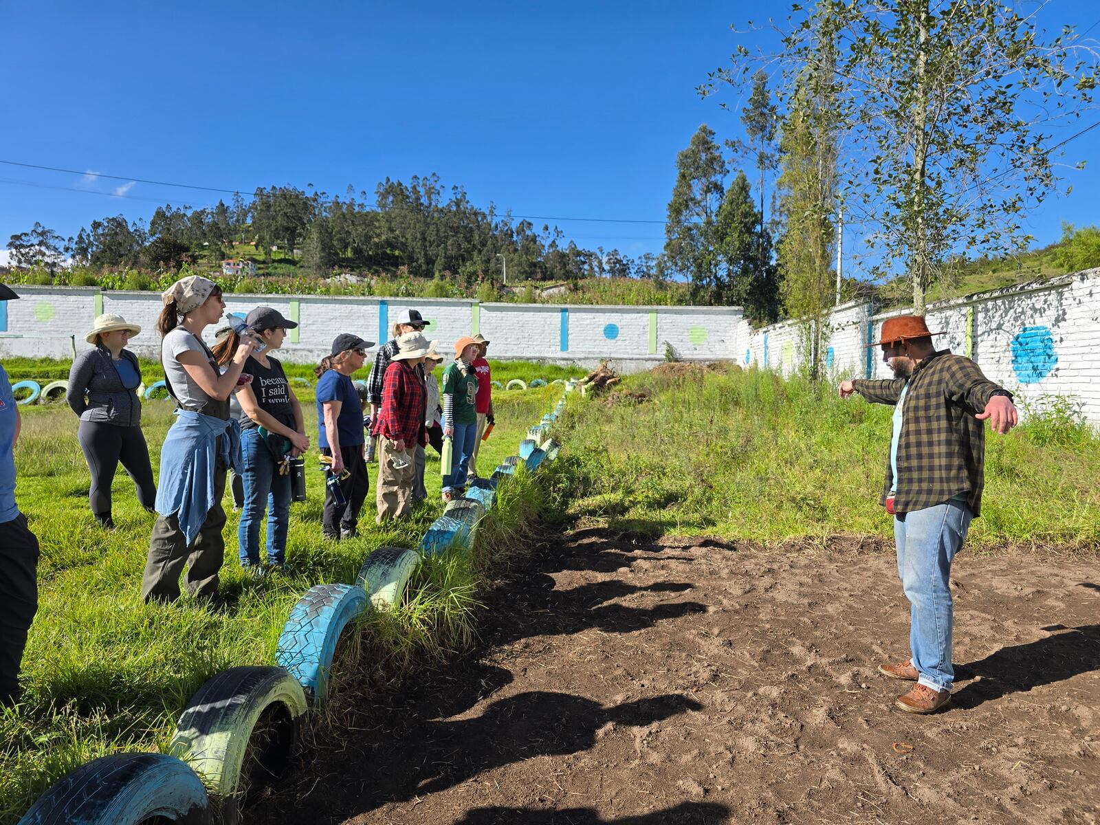 Getting instructions from the leader on how to remove the grass and weeds from the garden in the background. CONTRIBUTED