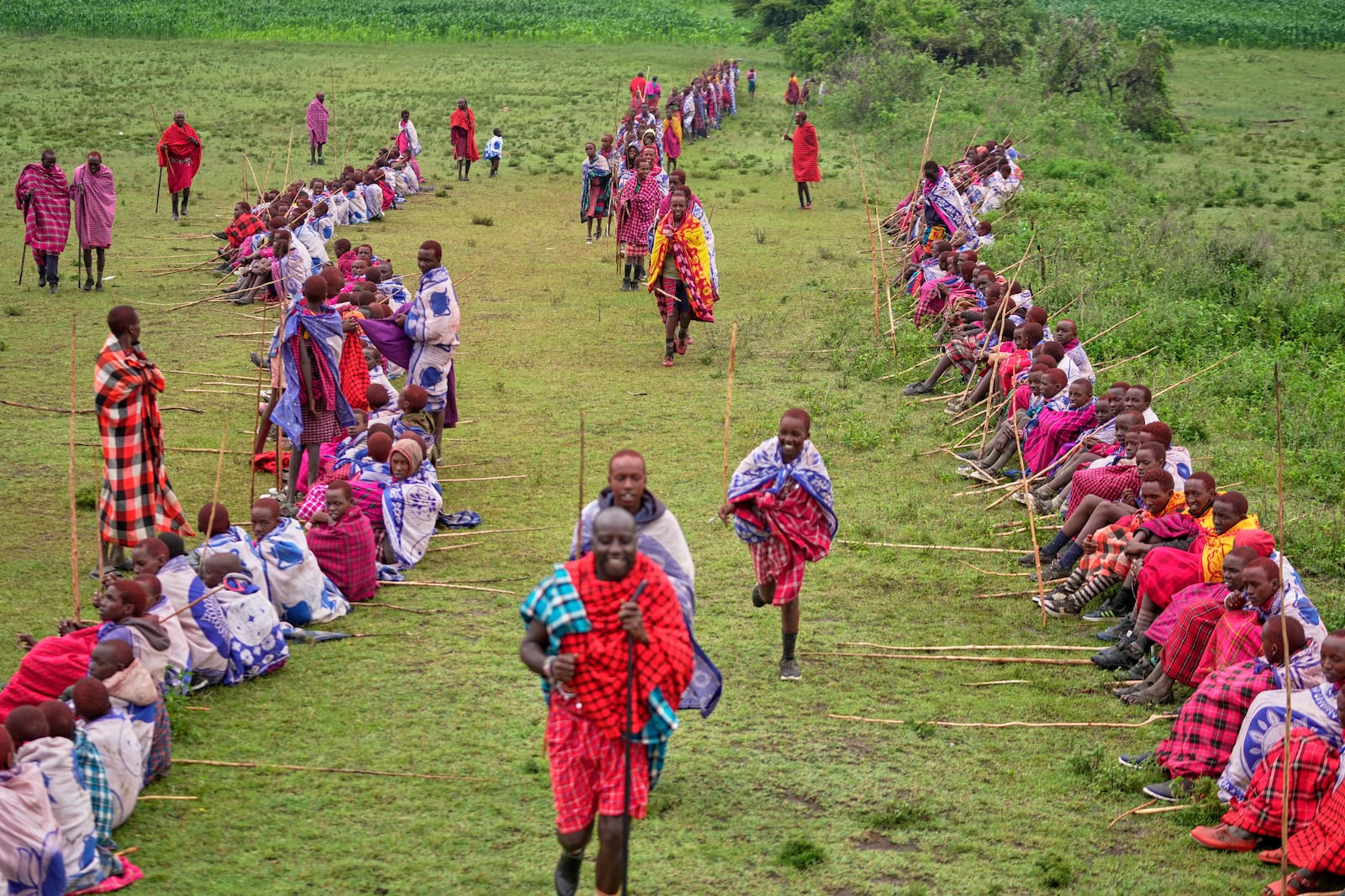 Children of the Maasai tribe gather on an open field, during the Enkipaata ceremony, a Maasai male rite of passage, specifically the initiation of boys, marking the transition from childhood to becoming a moran (warrior) in Olaimutiai, Narok County, Kenya Thursday, April 24, 2024. (AP Photo/Brian Inganga)