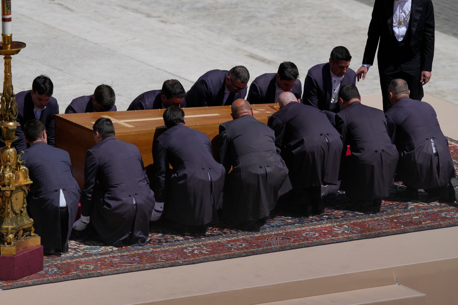 Pallbearers bend to lift the coffin of Pope Francis at the end of his funeral in St. Peter's Square at the Vatican, Saturday, April 26, 2025. (AP Photo/Gregorio Borgia)