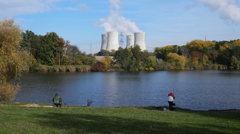 People fish near the towering Dukovany nuclear power plant, background, in Dukovany, Czech Republic, Oct. 21, 2025. (AP Photo/Petr David Josek)