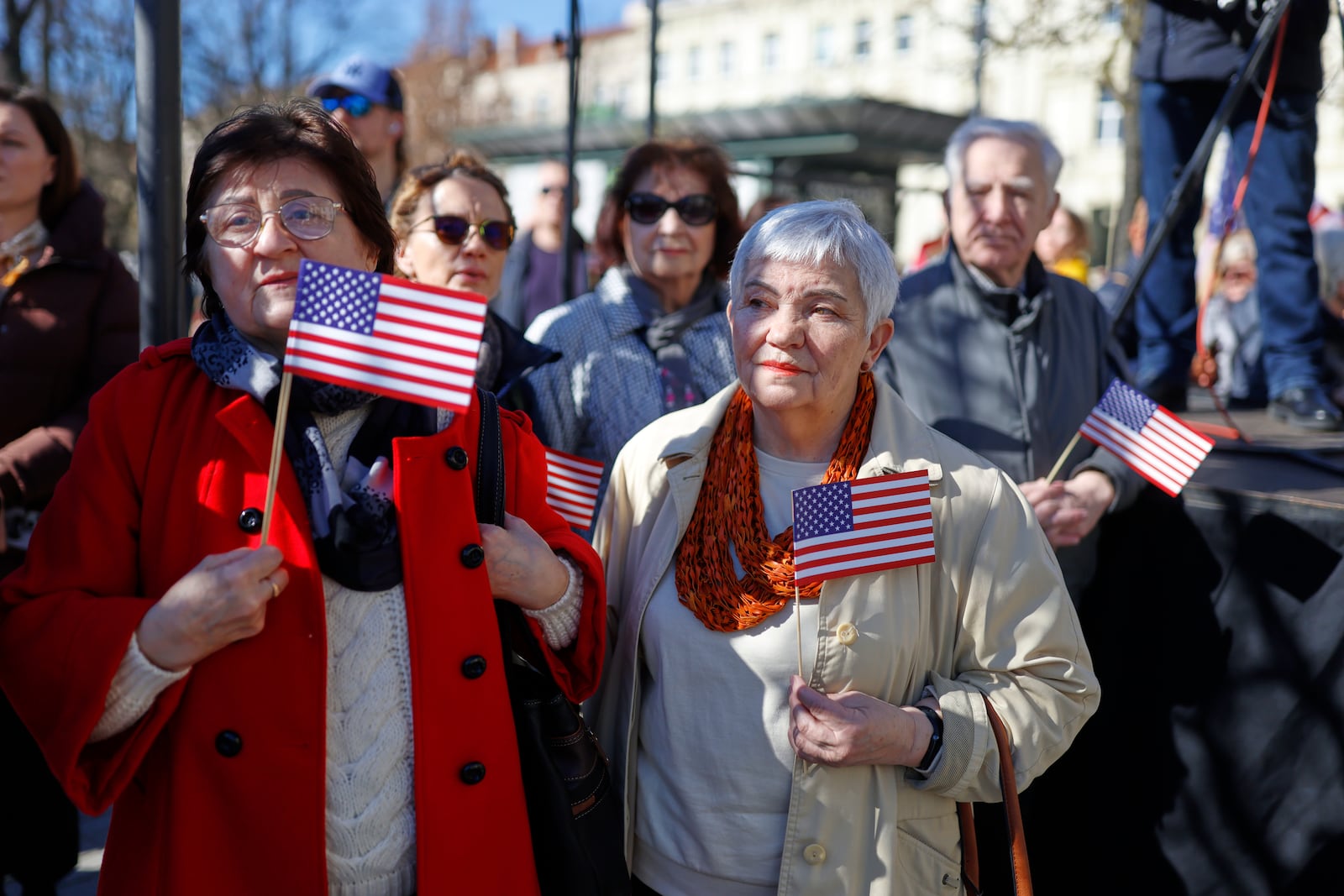 People with U.S. national flags attend a solemn farewell ceremony at Cathedral Square in Vilnius, Lithuania, Thursday, April 3, 2025 for the US soldiers who died during training exercise. (AP Photo/Mindaugas Kulbis)