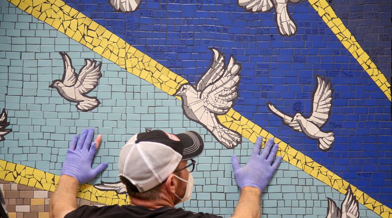 '9 Doves,' a mosaic mural created by the community to honor the nine people killed in the Oregon District mass shooting last year, was hung Tuesday, Aug. 3 in the lobby of City Hall. LISA POWELL / STAFF