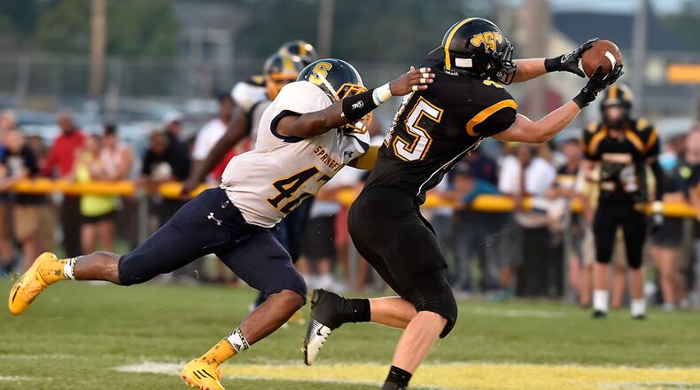 Shawnee's David Barnett catches a pass under pressure from Springfield's KaWambee Moss in open field during Friday's game at Shawnee. Bill Lackey/Staff