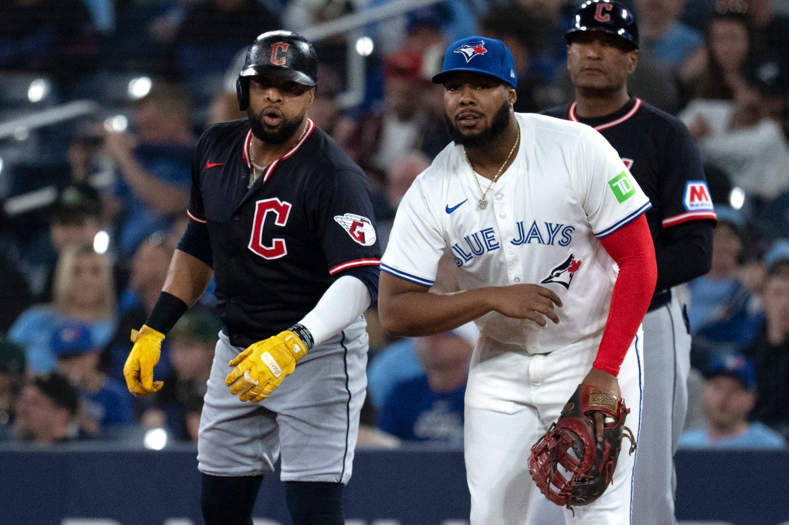 Cleveland Guardians' Carlos Santana, left, jokes with Toronto Blue Jays first baseman Vladimir Guerrero Jr during the first inning of a baseball game in Toronto, Saturday, May 3, 2025. (Jon Blacker/The Canadian Press via AP)
