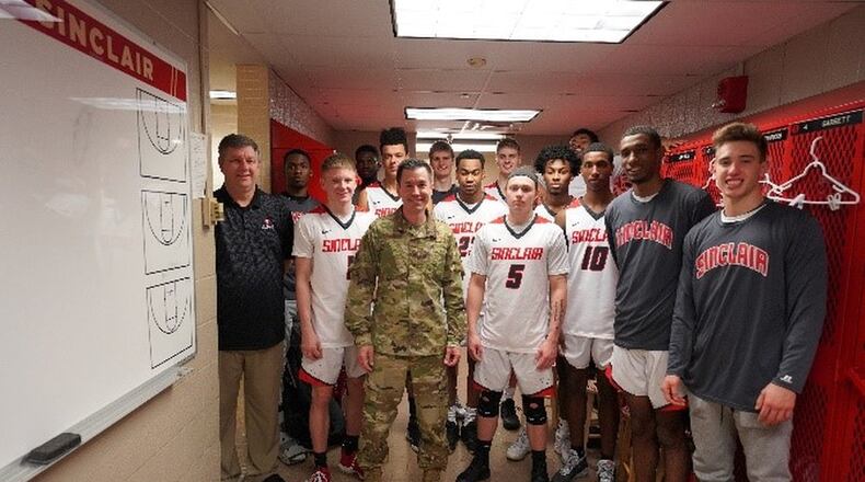 Colonel Paul Burger, Commander off 88th Mission Support Group at Wright Patterson Air Force Base, poses with the Sinclair men’s basketball team in locker room just before Monday’s game as part of Military Appreciation Night. Eric Deeters/Sinclair Community College