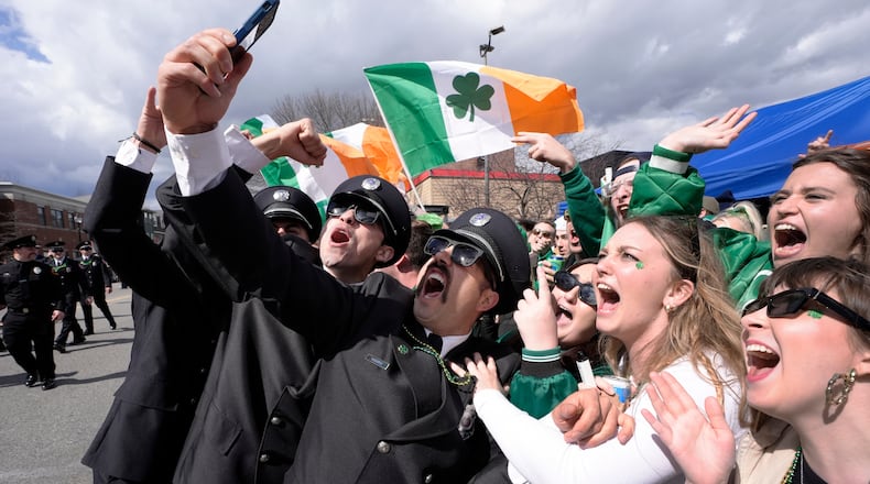 FILE - A group of firemen from around the United States pose for a selfie with spectators while marching in the St. Patrick's Day parade, March 17, 2024, in Boston's South Boston neighborhood. (AP Photo/Steven Senne, File)