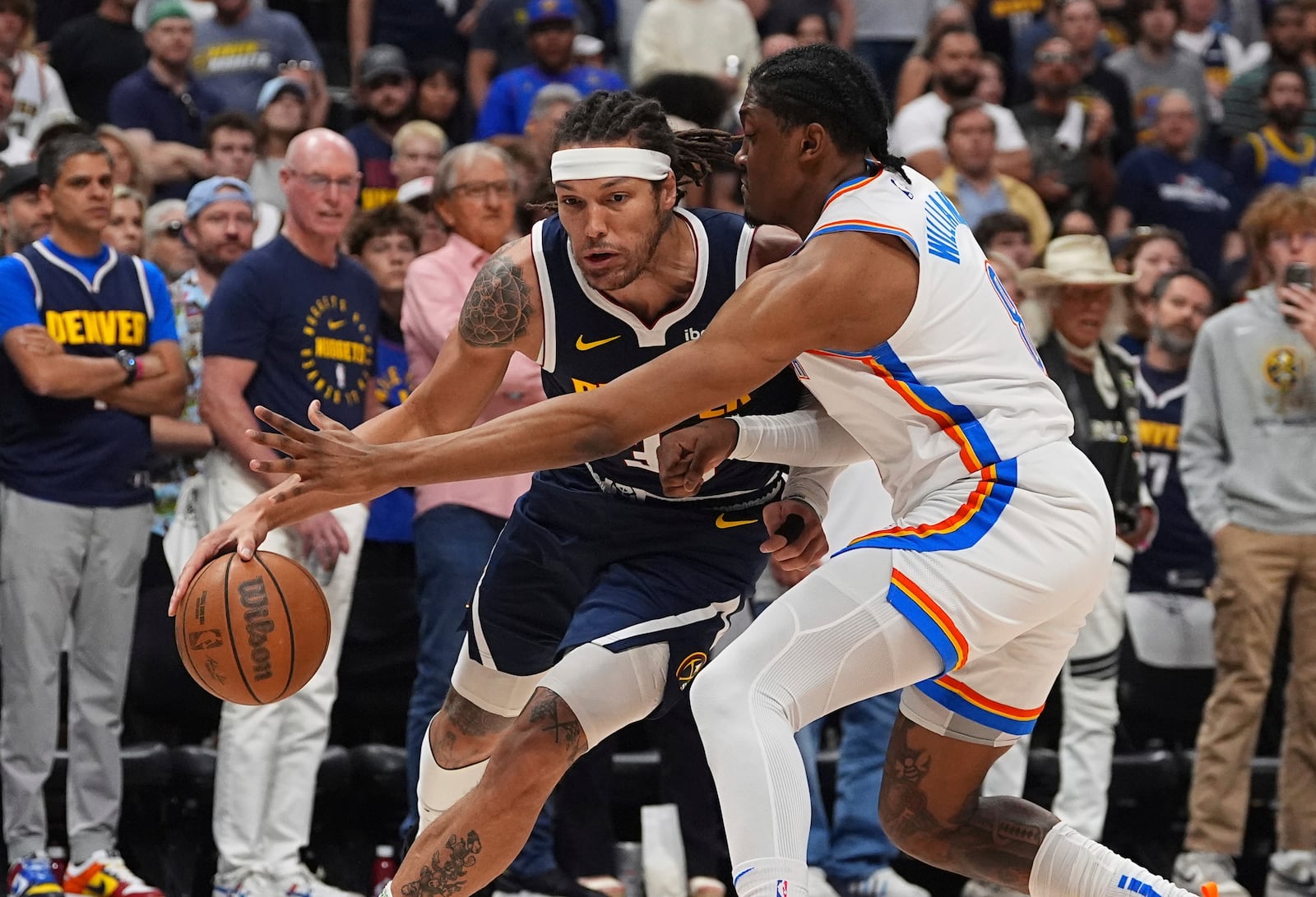 Denver Nuggets forward Aaron Gordon, left, drives past Oklahoma City Thunder forward Jalen Williams, right, in the first half of Game 4 in the Western Conference semifinals of the NBA basketball playoffs Sunday, May 11, 2025, in Denver. (AP Photo/David Zalubowski)