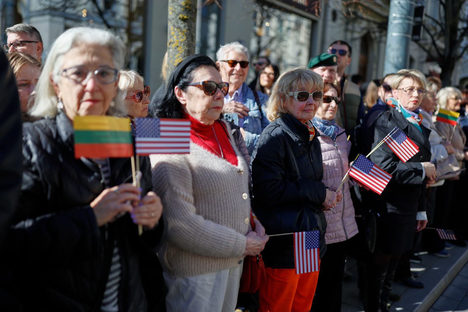 People with U.S. and Lithuanian national flags attend a solemn farewell ceremony at Cathedral Square in Vilnius, Lithuania, Thursday, April 3, 2025 for the US soldiers who died during training exercise. (AP Photo/Mindaugas Kulbis)