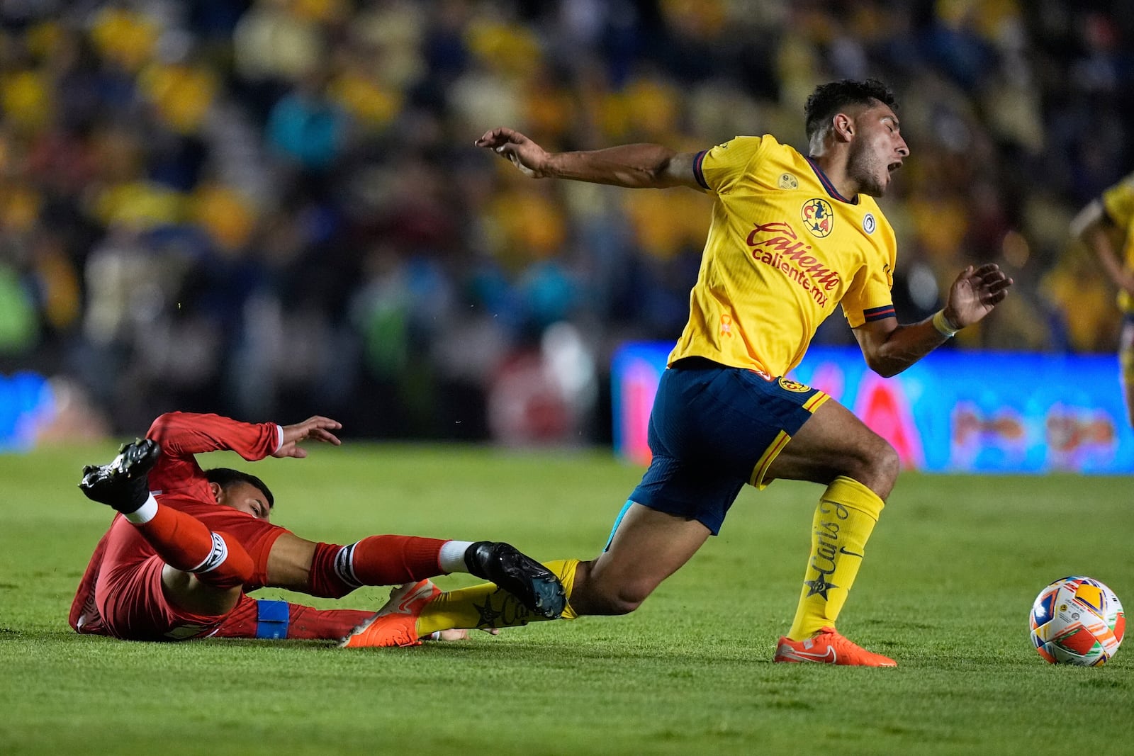 Toluca's Alexis Vega, left, tackles America's Sebastian Caceres during the Mexican soccer league first leg final match in Mexico City, Thursday, May 22, 2025. (AP Photo/Fernando Llano)