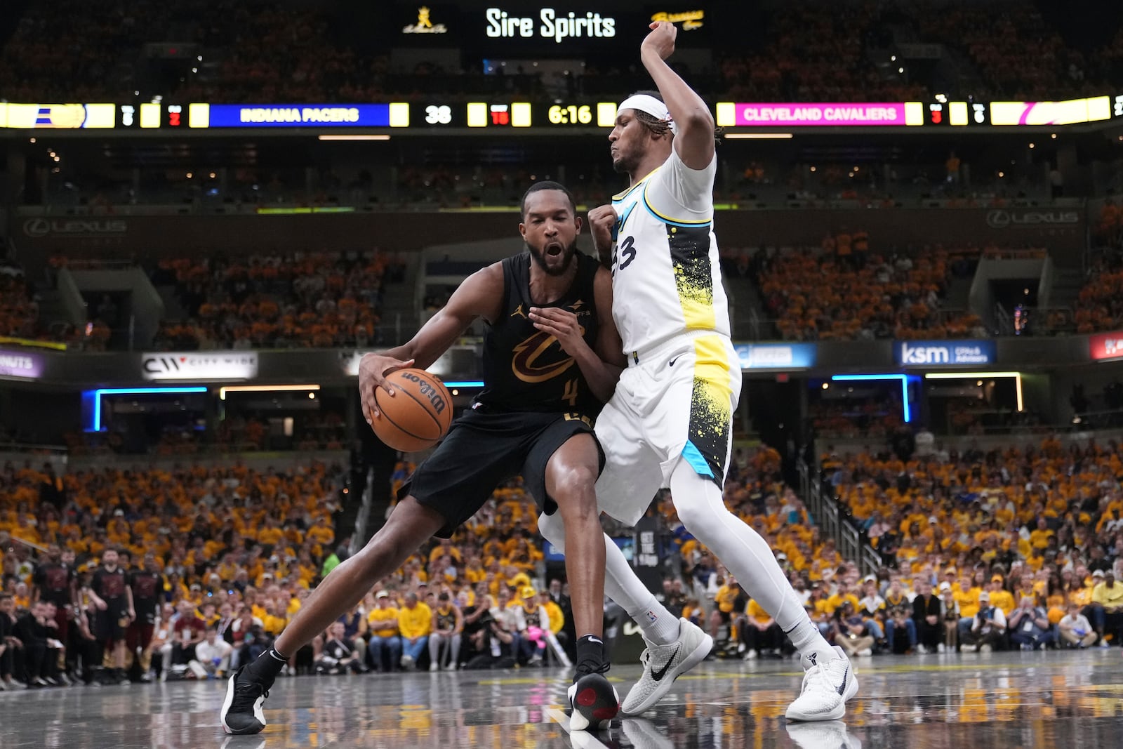 Cleveland Cavaliers center Evan Mobley (4) dribbles the ball against Indiana Pacers center Myles Turner (33) during the first half of Game 3 in the Eastern Conference semifinals of the NBA basketball playoffs in Indianapolis, Friday, May 9, 2025. (AP Photo/Michael Conroy)