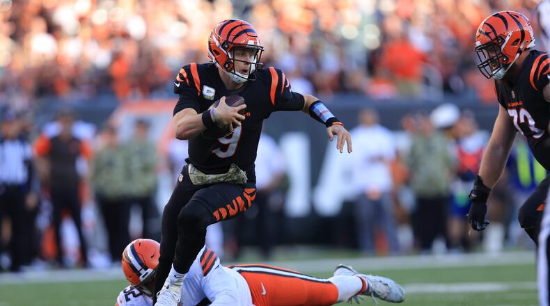 Cincinnati Bengals quarterback Joe Burrow (9) runs from Cleveland Browns' Sheldon Day during the second half of an NFL football game, Sunday, Nov. 7, 2021, in Cincinnati. (AP Photo/Aaron Doster)