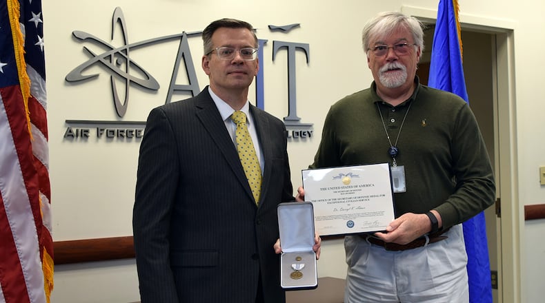 Dr. Darryl Ahner, dean for research within the Air Force Institute of Technology’s Graduate School of Engineering and Management, was re-presented the Secretary of Defense Medal for Exceptional Civilian Service by Dr. Walter Jones, AFIT director and chancellor. Ahner received the award for his leadership, commitment and professional expertise as the director of AFIT’s Scientific Test and Analysis Techniques Center of Excellence.  U.S. AIR FORCE PHOTO/KATIE SCOTT