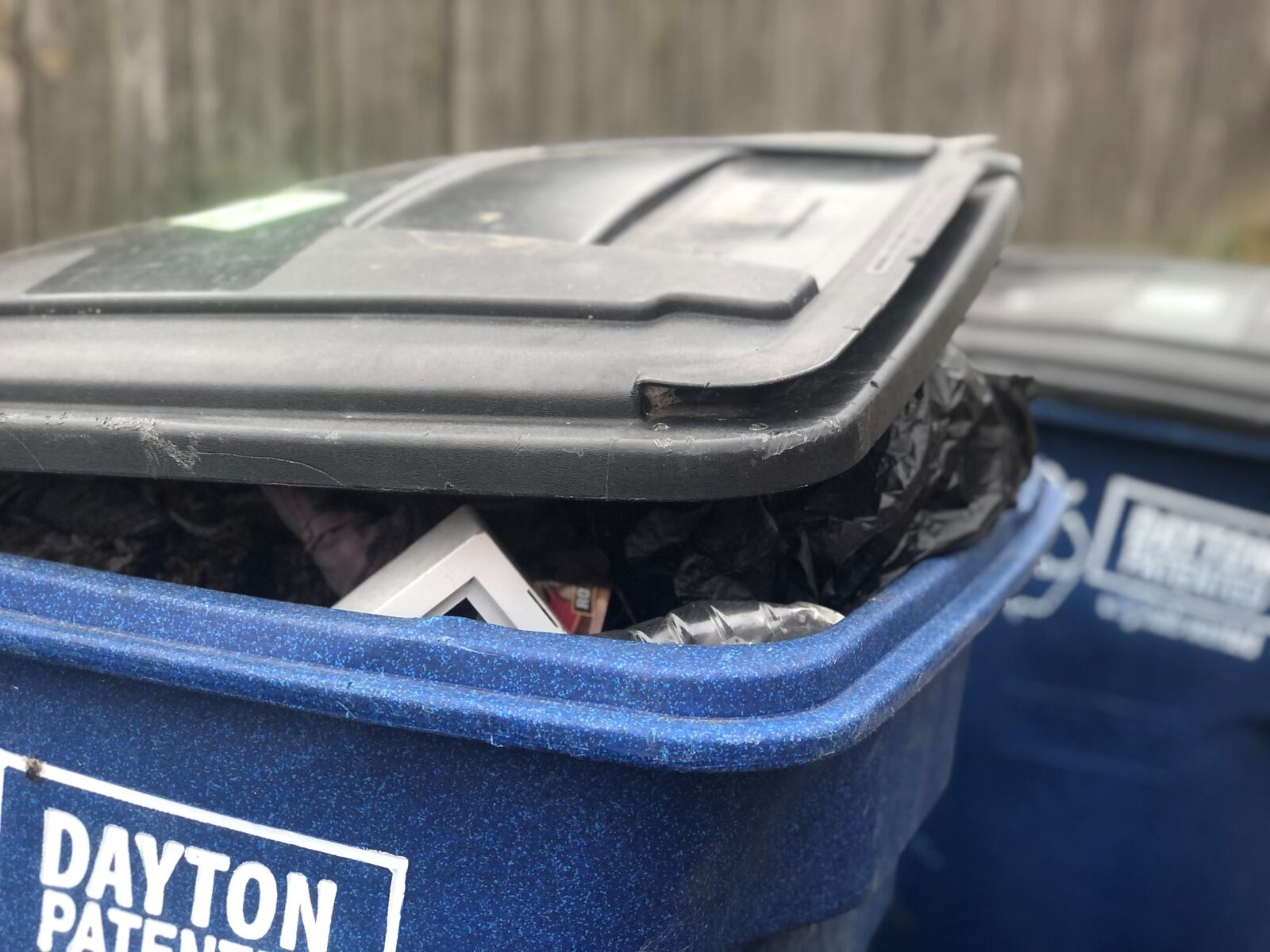 A pair of blue recycling bins in the South Park neighborhood were not emptied this month because they contained nonrecyclable trash, including fabrics. City crews put "oops" warning stickers on the containers. CORNELIUS FROLIK / STAFF