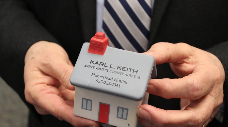 Montgomery County Auditor Karl Keith holds a foam desktop toy with the phone number citizens can call to learn more about the homestead exemption program. CORNELIUS FROLIK / STAFF