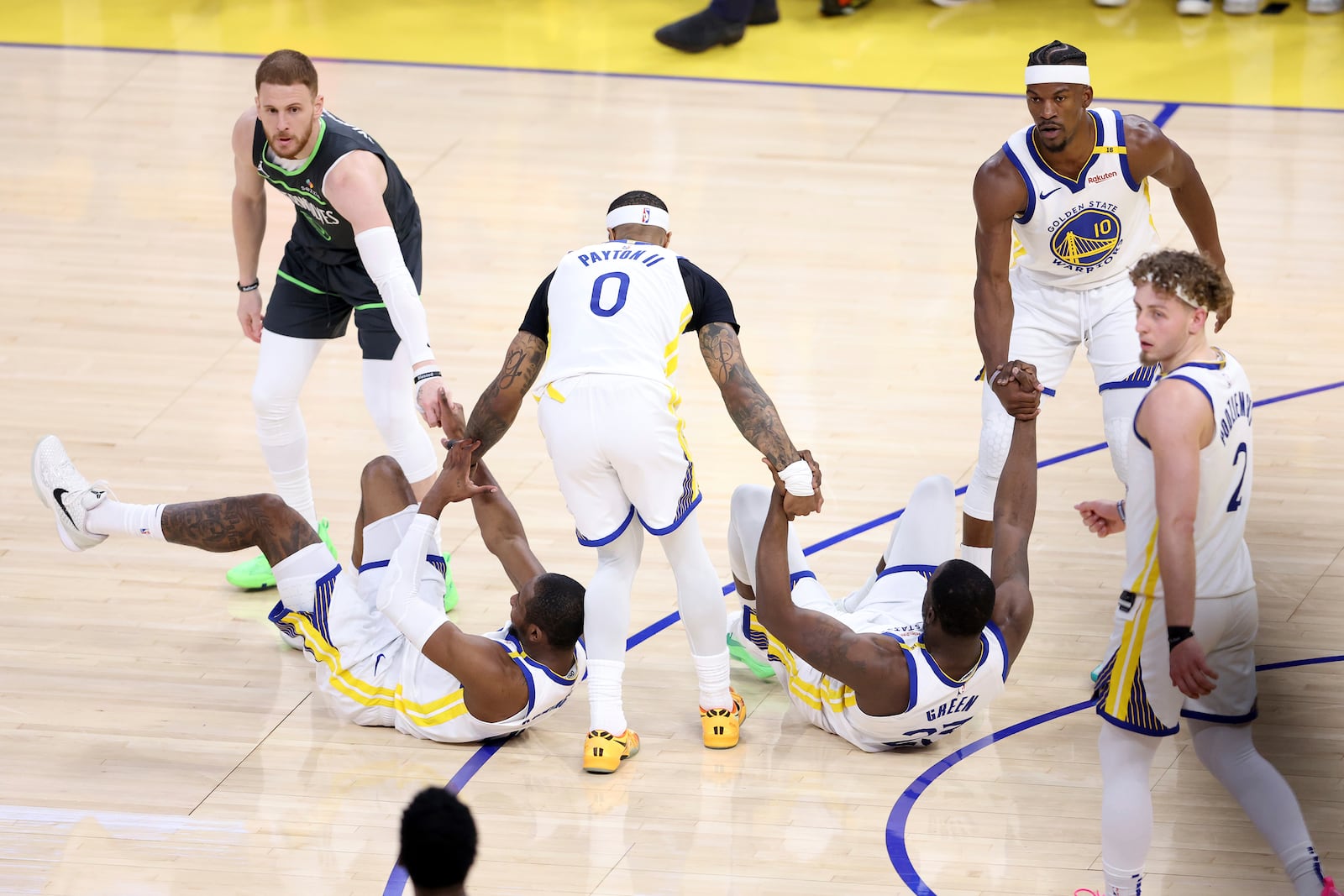 Golden State Warriors' Draymond Green and Jonathan Kuminga are helped up by Gary Payton II, Jimmy Butler III and Minnesota Timberwolves' Donte Divincenzo in 1st quarter during NBA Western Conference Semifinals' Game 3 at Chase Center in San Francisco on Saturday, May 10, 2025. (Scott Strazzante/San Francisco Chronicle via AP)