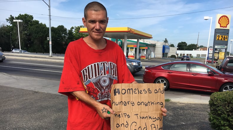 Charles Young holds a sign near the intersection of U.S. 35 and Smithville Road. “I’ve been looking for a job. It’s just been rough. I don’t want to do this. I want to get off the street,” he said.