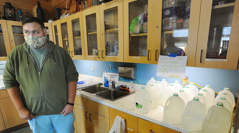 Sean Mormino, environmental education and animal care coordinator at the Aullwood Audubon Farm Discovery Center, stands near jugs the staff uses to transport water for animals after PFAS was discovered in the facility's drinking water system. MARSHALL GORBY\STAFF
