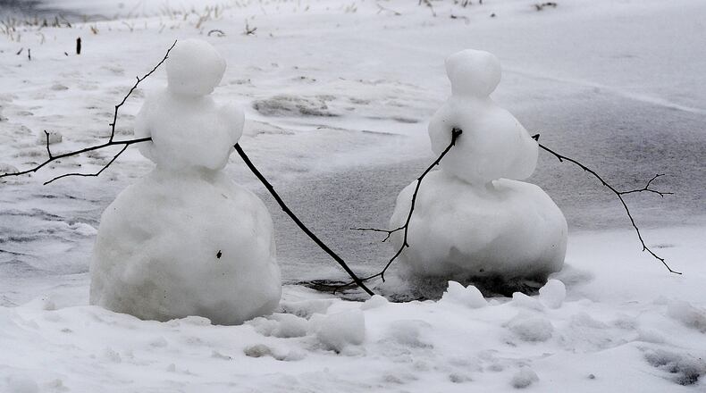 Someone built two little snowmen on the sidewalk near the University of Dayton campus Monday, Feb. 1, 2021.