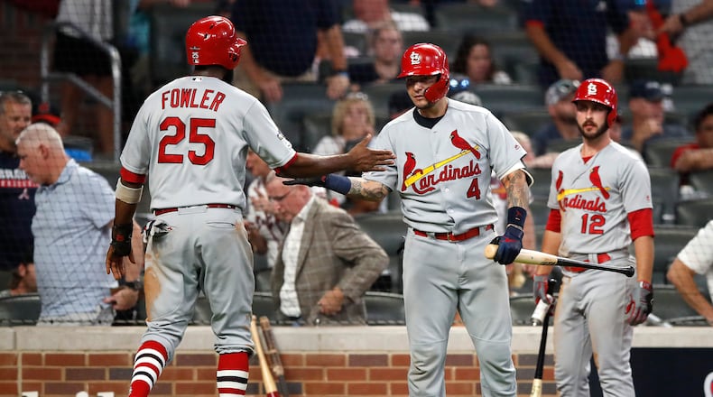 ATLANTA, GEORGIA - OCTOBER 03: Dexter Fowler #25 of the St. Louis Cardinals is congratulated by his teammate Yadier Molina #4 after scoring a run against the Atlanta Braves during the ninth inning in game one of the National League Division Series at SunTrust Park on October 03, 2019 in Atlanta, Georgia. (Photo by Todd Kirkland/Getty Images)