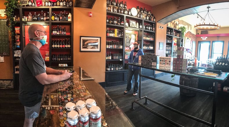 The Barrel House Craft Beer Pro, Scott Ross, waits for carry out customers to come through the door Thursday afternoon. Before coronavirus the establishment had 40 customers daily. JIM NOELKER\STAFF