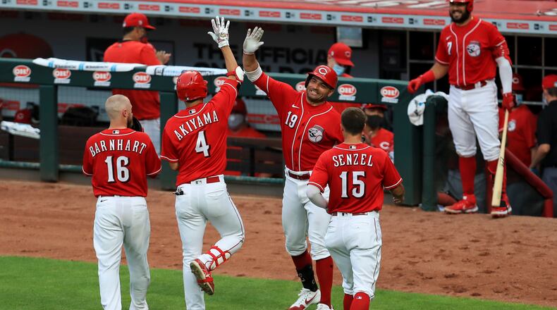 Cincinnati Reds' Shogo Akiyama (4) celebrates with Joey Votto (19) after hitting a three-run home run during the fifth inning of an exhibition baseball game against the Detroit Tigers at Great American Ballpark in Cincinnati, Tuesday, July 21, 2020. (AP Photo/Aaron Doster)