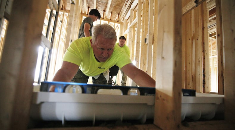 Workers are building ranch-style patio homes at Cottages of Beavercreek, a Charles Simms Development project. Twenty of 80 planned homes have been built and they are priced at $250,000 to $325,000. TY GREENLEES / STAFF