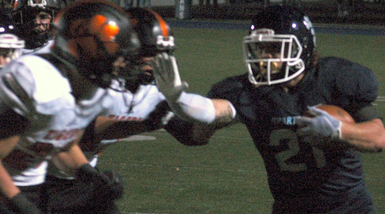 Valley View’s Collin Genslinger stiff arms a Waverly defender during the Spartans 42-0 win over Waverly in the first round of the Division IV, Region 16 playoffs Friday night at Barker Field. John Cummings/CONTRIBUTED