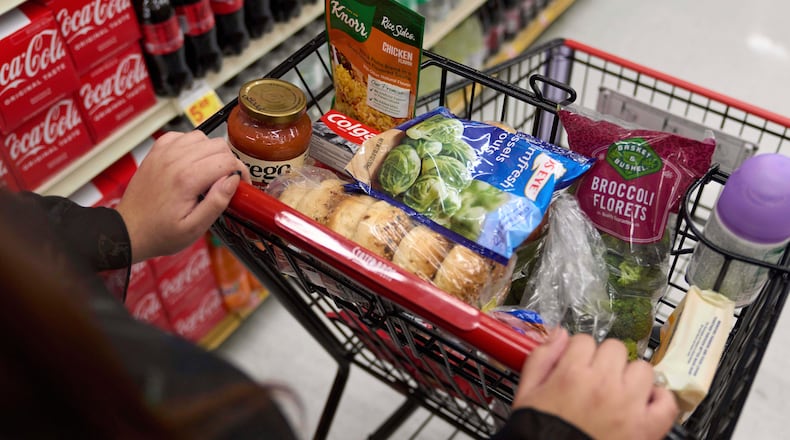FILE - A California's SNAP benefits shopper pushes a cart through a supermarket in Bellflower, Calif., Feb. 13, 2023. (AP Photo/Allison Dinner, File)
