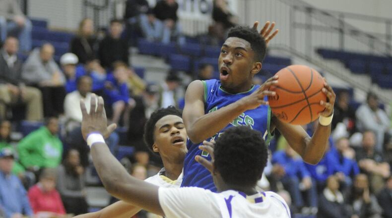 Chaminade Julienne’s P’Hariz Watkins (with ball) splits Thurgood Marshall defenders Kadiem Jones (left) and Tommy Richardson. CJ defeated Thurgood 53-43 in a boys high school basketball D-II sectional semifinal at Fairmont’s Trent Arena on Monday, Feb. 27, 2017. MARC PENDLETON / STAFF