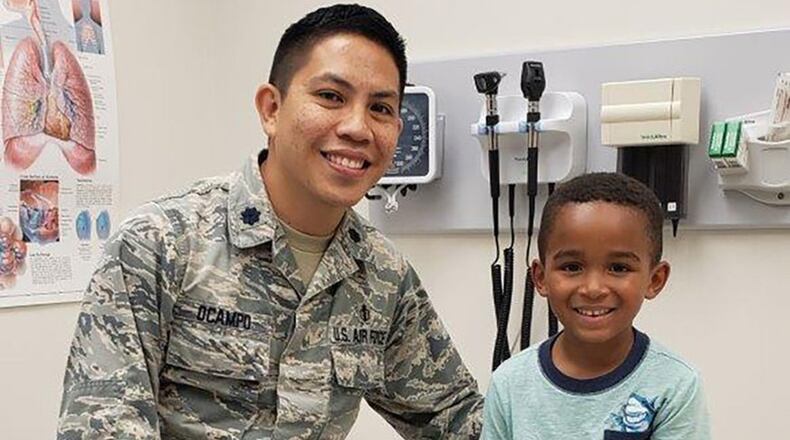 Lt. Col. Thad O’Campo, a physician at Wright-Patterson Medical Center, sits with Vincent Machi who is wearing a new arm brace in the pediatric clinic a part of Wright-Patterson Medical Clinic. O’Campo, a neighbor of Vincent’s, was nearby when the boy took a spill from playground equipment and acted quickly to stabilize the injury with a makeshift splint. (Courtesy photo)
