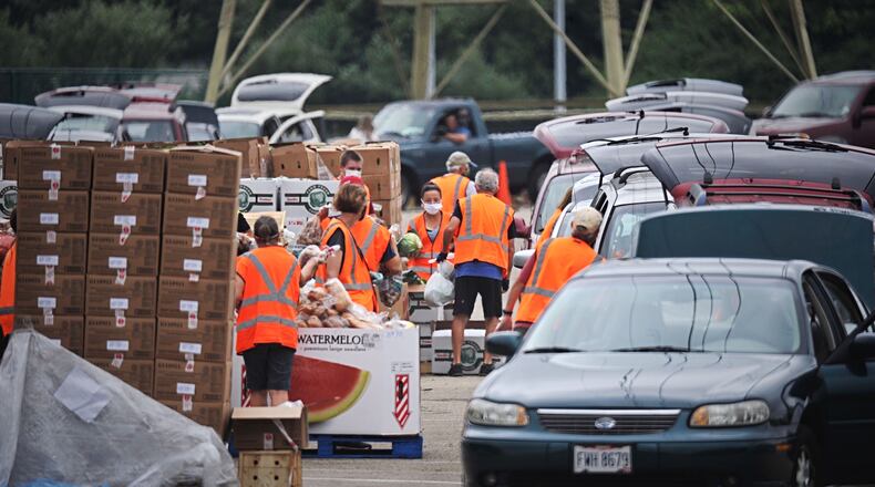 The Foodbank gave away food Thursday at Wright State University's Nutter Center as part of a mass food distribution. It was the third food distribution event held at the Nutter Center since the pandemic started. STAFF PHOTO / MARSHALL GORBY