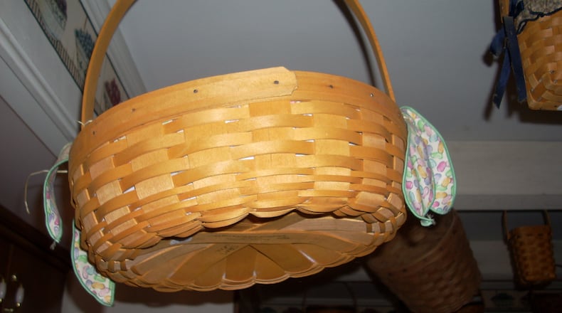 A Longaberger basket tagged for sale at a recent Kettering estate sale hung from the ceiling with a group of other baskets in the owner’s collection.