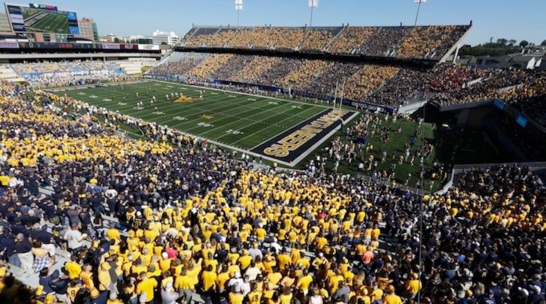 FILE - In this Saturday, Oct. 14, 2017, file photo, West Virginia fans stripe the stadium in blue and gold during an NCAA college football game against Texas Tech in Morgantown, W.Va. When a school wants to "stripe" its stadium in school colors, as West Virginia did last week before its game with Texas Tech, school officials merely have to remind fans on Twitter which color to wear based on where they'll be sitting. (AP Photo/Raymond Thompson, File)