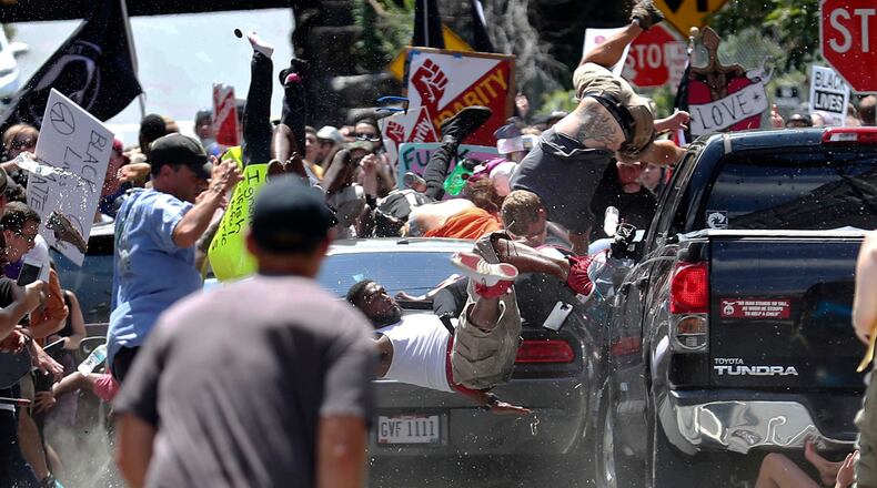 People fly into the air as a vehicle drives into a group of protesters demonstrating against a white nationalist rally in Charlottesville, Va., Saturday, Aug. 12, 2017. The nationalists were holding the rally to protest plans by the city of Charlottesville to remove a statue of Confederate Gen. Robert E. Lee. (Ryan M. Kelly/The Daily Progress via AP)