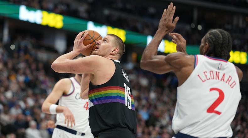 Denver Nuggets center Nikola Jokić (15) goes up for a basket as Los Angeles Clippers forward Kawhi Leonard (2) defends in the first half of an NBA basketball game Friday, Jan. 30, 2026, in Denver. (AP Photo/David Zalubowski)
