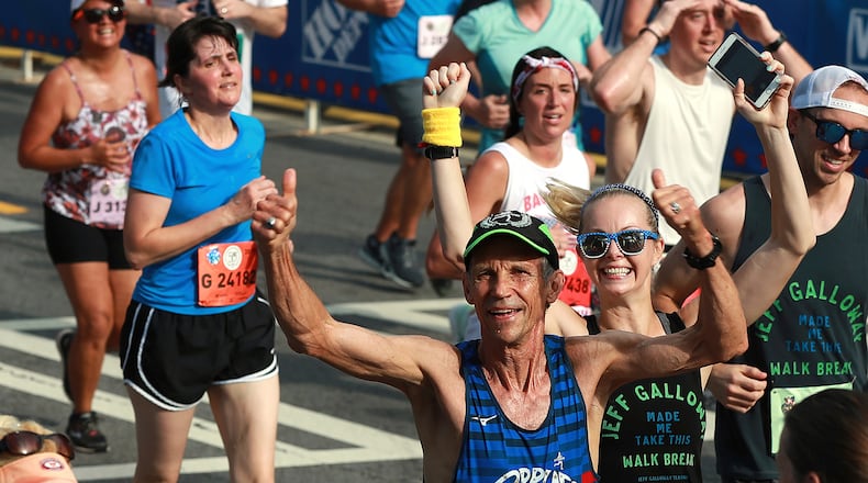 FILE - Jeff Galloway, the first winner of the race at its original running, gives a double thumbs up as he heads to the finish line in the 50th AJC Peachtree Road Race, Thursday, July 4, 2019, in Atlanta. (Curtis Compton//Atlanta Journal-Constitution via AP, File)