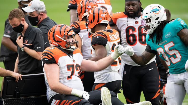 Miami Dolphins safety Kavon Frazier (35) bump fists Cincinnati Bengals offensive tackle Jonah Williams (73) who was injured and carted off the field during an NFL football game, Sunday, DEC. 6, 2020, in Miami Gardens, Fla. (AP Photo/Doug Murray)