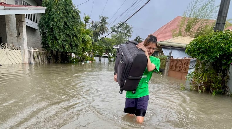 A resident navigates a flooded street as they evacuate to safer grounds as Typhoon Kalmaegi affects Cebu city, central Philippines, Tuesday Nov. 4, 2025. (AP Photo/Jacqueline Hernandez)