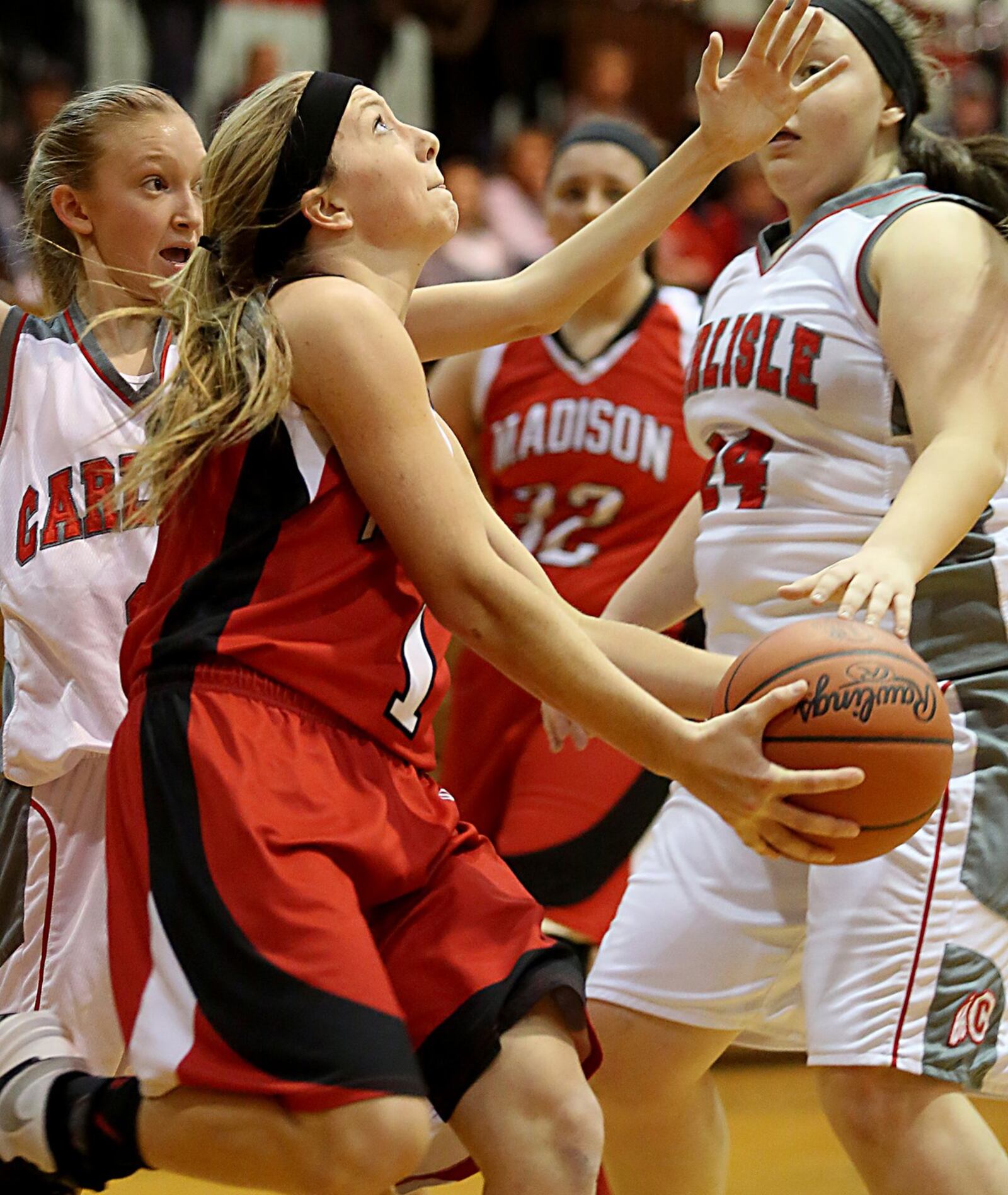 Madison’s Jenna O’Hair eyes the basket as Carlisle’s Caitlyn Stewart (left) and Cassidy Whaley (24) defend Saturday afternoon at Carlisle. CONTRIBUTED PHOTO BY E.L. HUBBARD