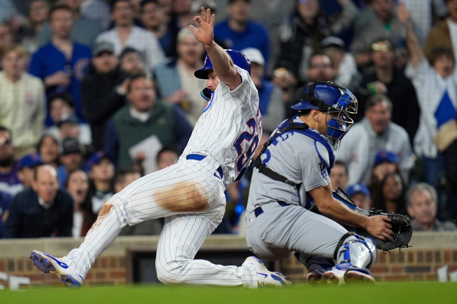 Chicago Cubs' Michael Busch (29) slides by Los Angeles Dodgers catcher Austin Barnes (15) to score on a sacrifice fly from Nic Hoerner during the fifth inning of a baseball game Wednesday, April 23, 2025, in Chicago. (AP Photo/Erin Hooley)