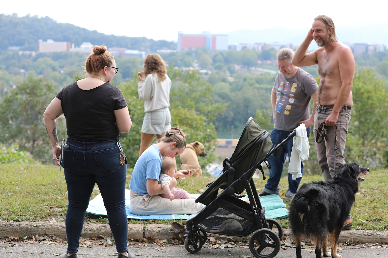 FILE - People gather on a hill in Asheville, North Carolina, where they can find a little cellphone service on Monday, Sept. 30, 2024. (AP Photo/Jeffrey Collins, File)