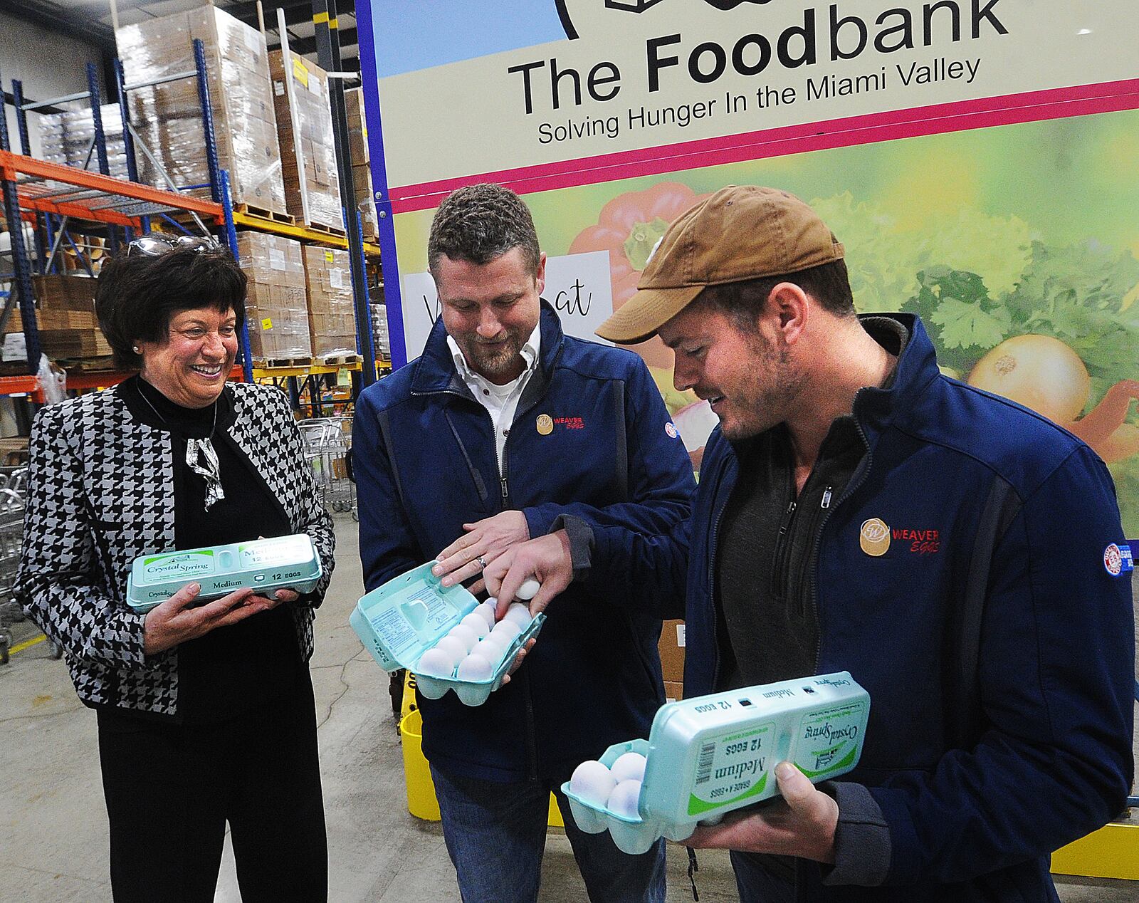 Michelle Riley, CEO of the Dayton Foodbank, left, Zach Kohli and Tim Weaver from Weaver Eggs look over three dozen of 54,000 eggs Weaver Eggs donated to The Foodbank Inc. on Tuesday, March 28, 2023, in Dayton. The contribution is part of a nationwide initiative by America’s egg farmers, called Fighting Hunger by the Dozens, which will provide 3 million eggs to food banks this spring. MARSHALL GORBY\STAFF