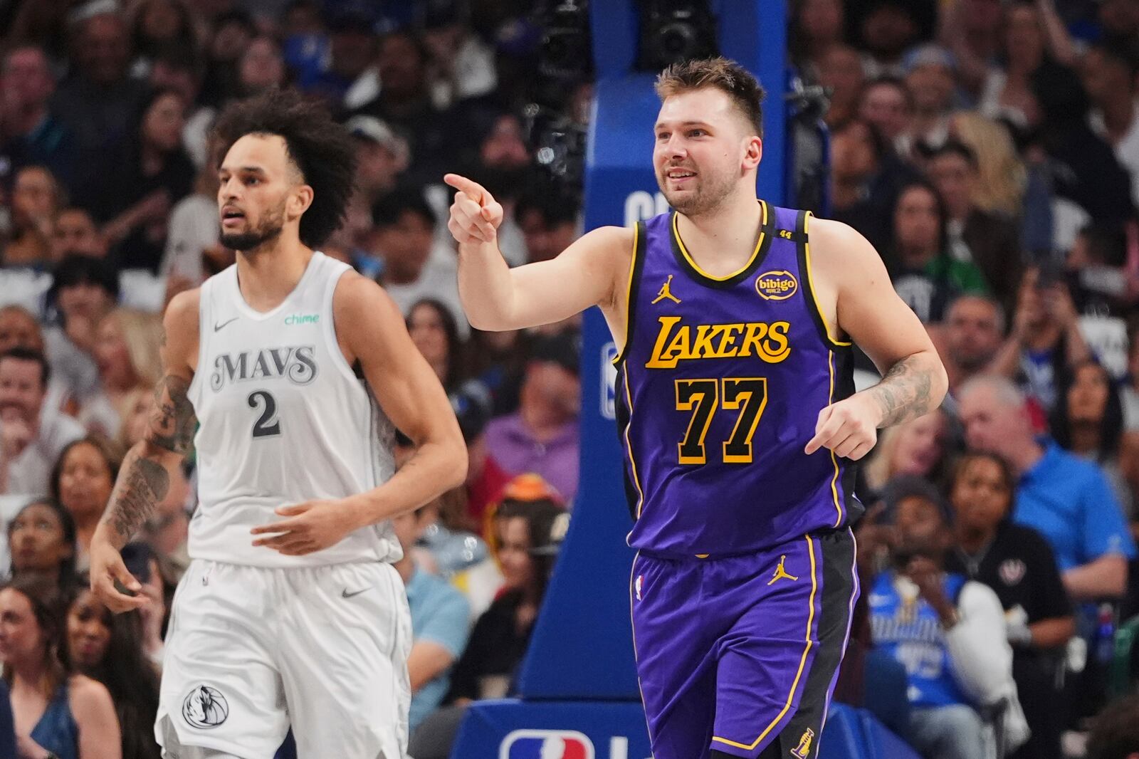 Los Angeles Lakers' Luka Doncic (77) celebrates sinking a basket as Dallas Mavericks' Dereck Lively II (2) follows behind in the first half of an NBA basketball game in Dallas, Wednesday, April 9, 2025. (AP Photo/LM Otero)