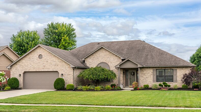 The brick ranch has about 3,040 sq. ft. of living space. Manicured landscaping surrounds the 3-bedroom house, which includes a 2-car garage and a rear concrete patio. CONTRIBUTED PHOTO/DAYTON HOME PHOTOGRAPHY